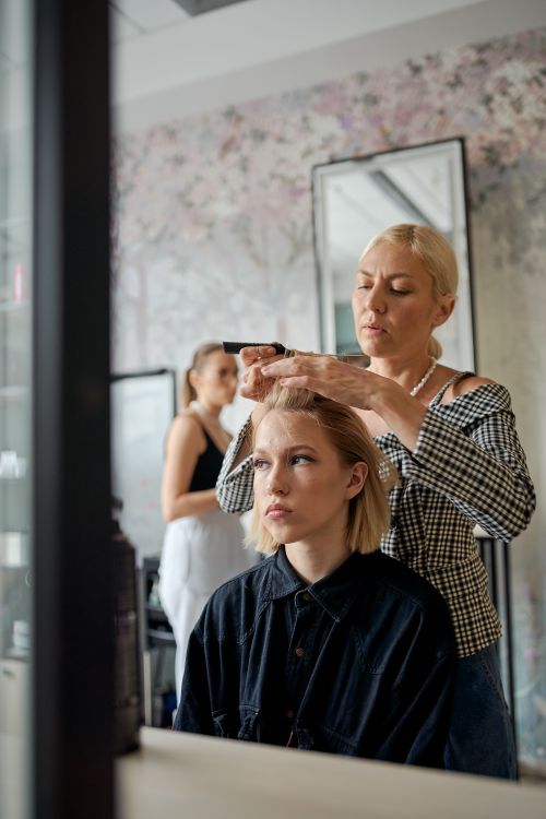 Coiffeuse coiffant une cliente en salon de coiffure