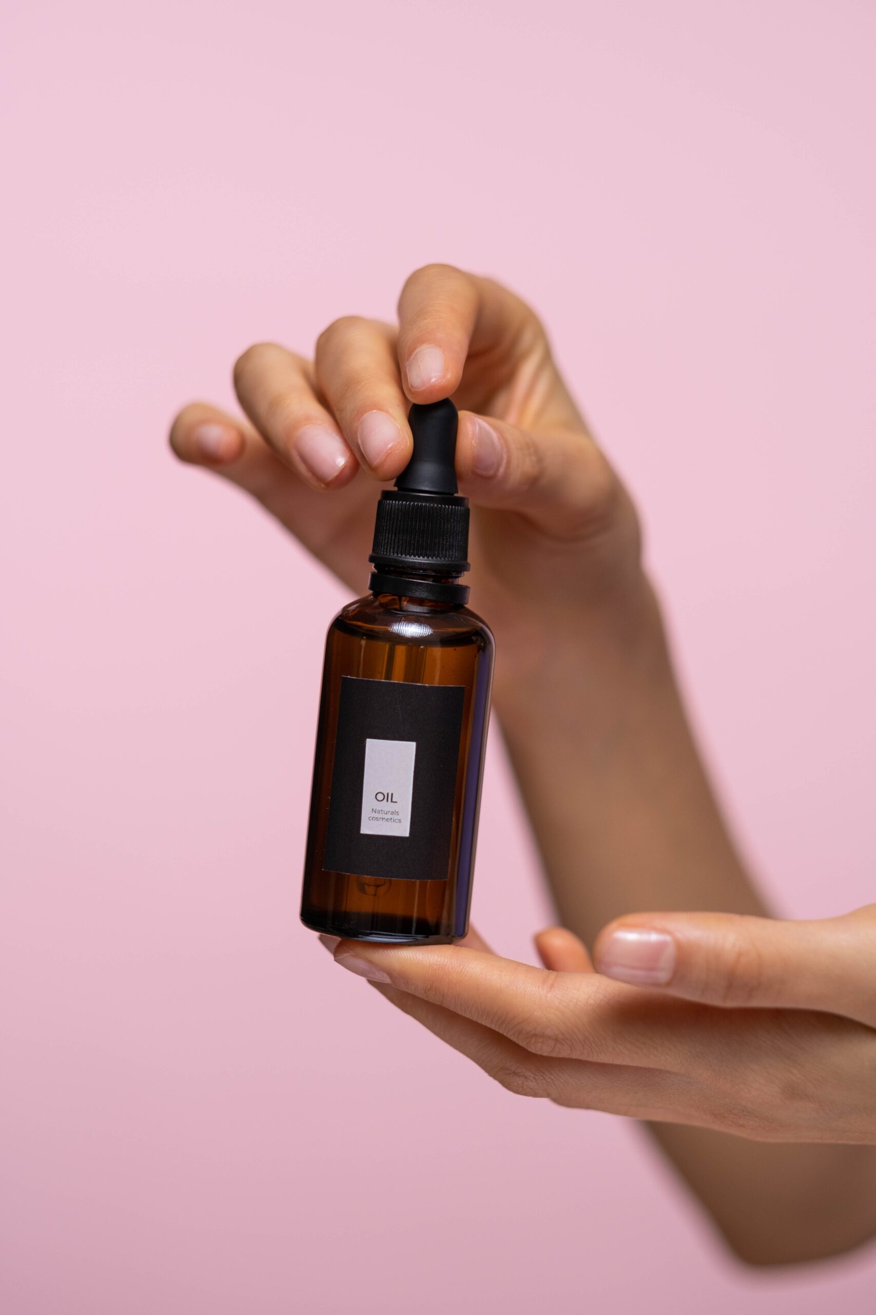 Personne tenant un flacon de sérum cosmétique