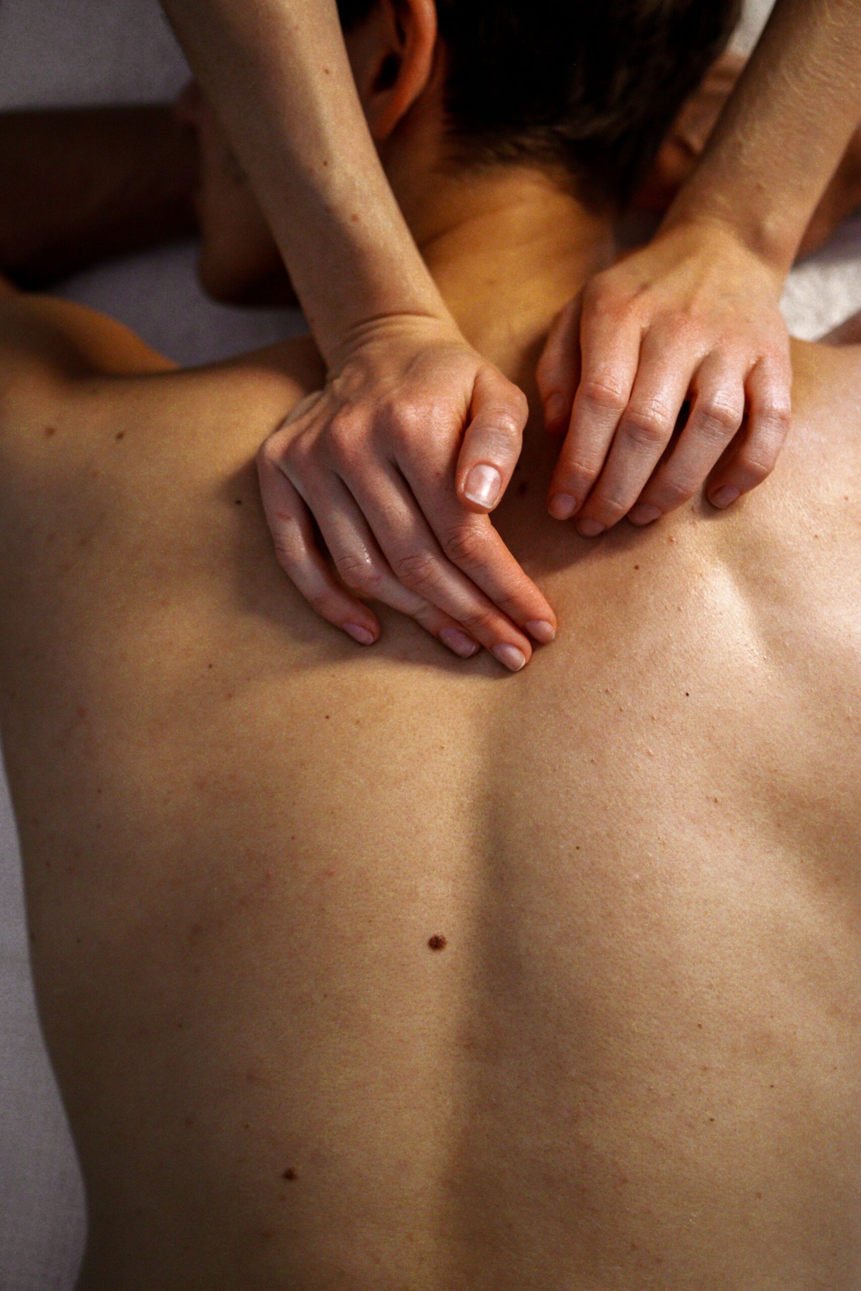Praticien réalisant des pressions de shiatsu sur le dos d'un client